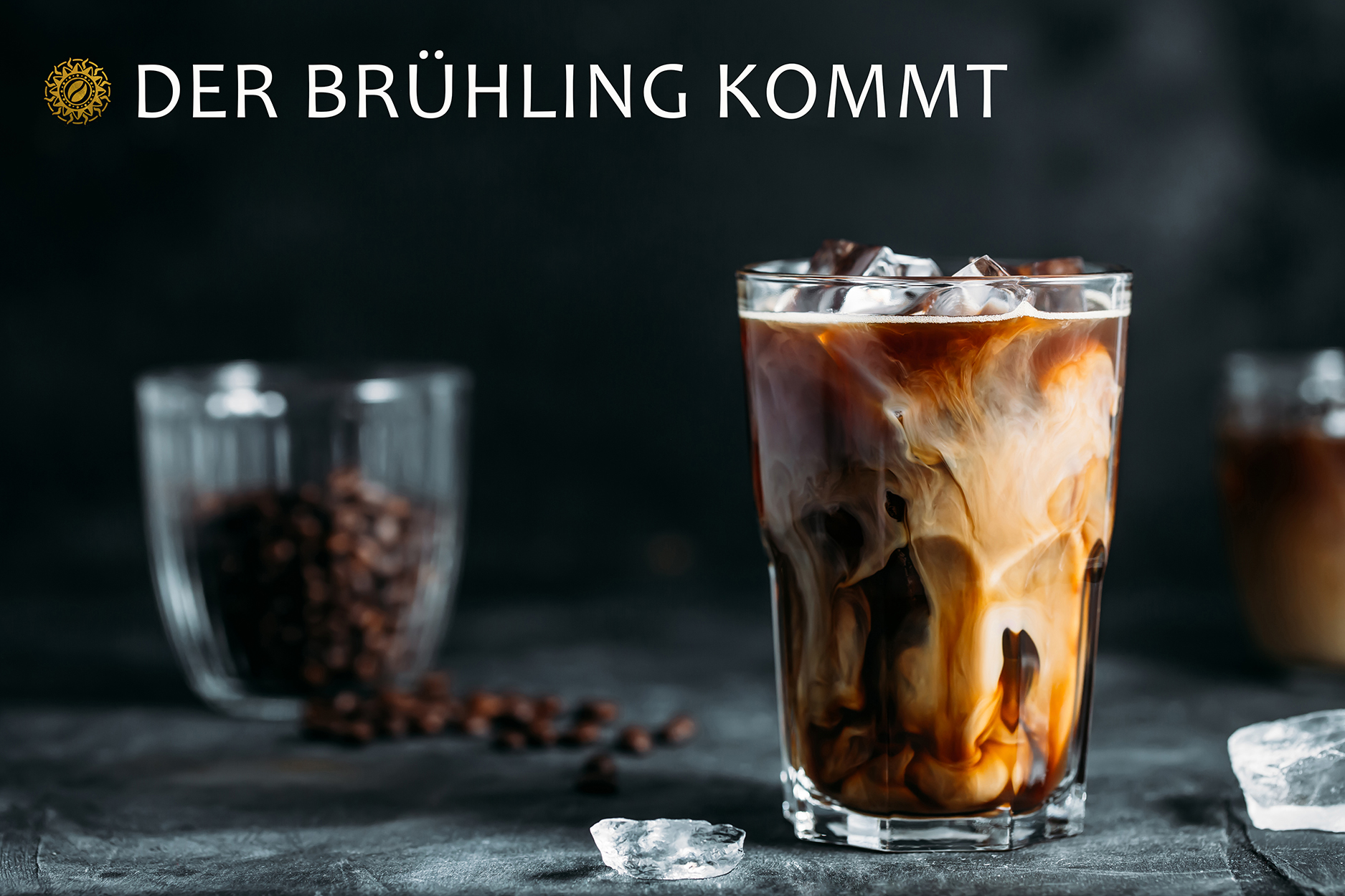 Ice coffee in a tall glass with cream poured over and coffee beans on dark gray background